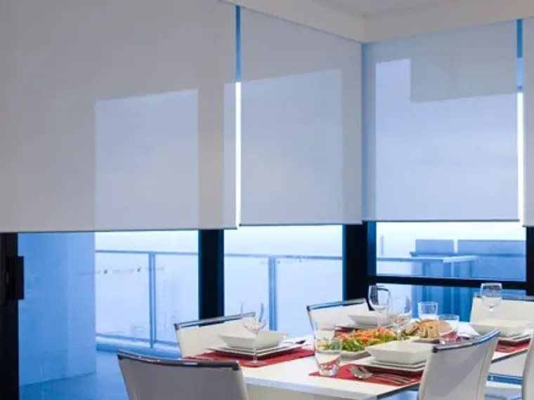 Comedor con cortinas roller screen que dejan ver el exterior
