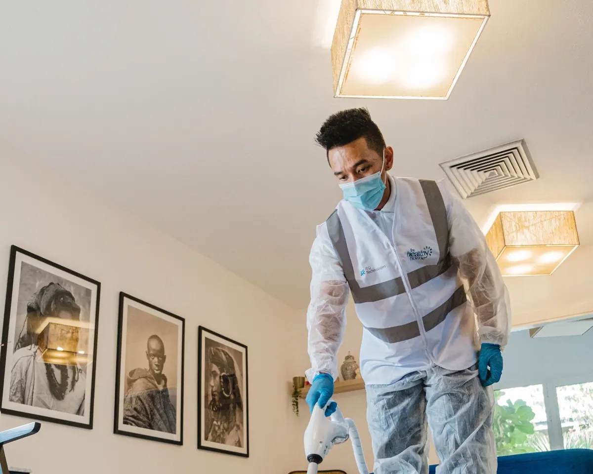 Técnico con guantes limpiando la tapicería de un sofá