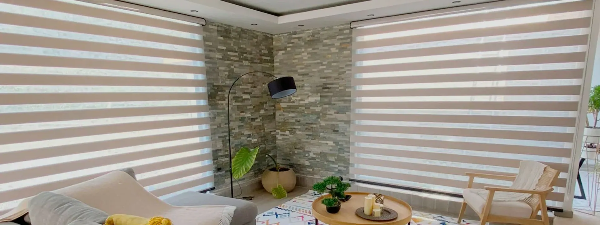Sala con cortinas roller duo de franjas horizontales frente a un ventanal