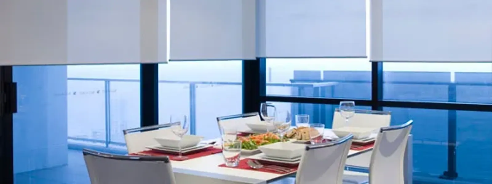 Comedor con cortinas roller screen que dejan ver el exterior