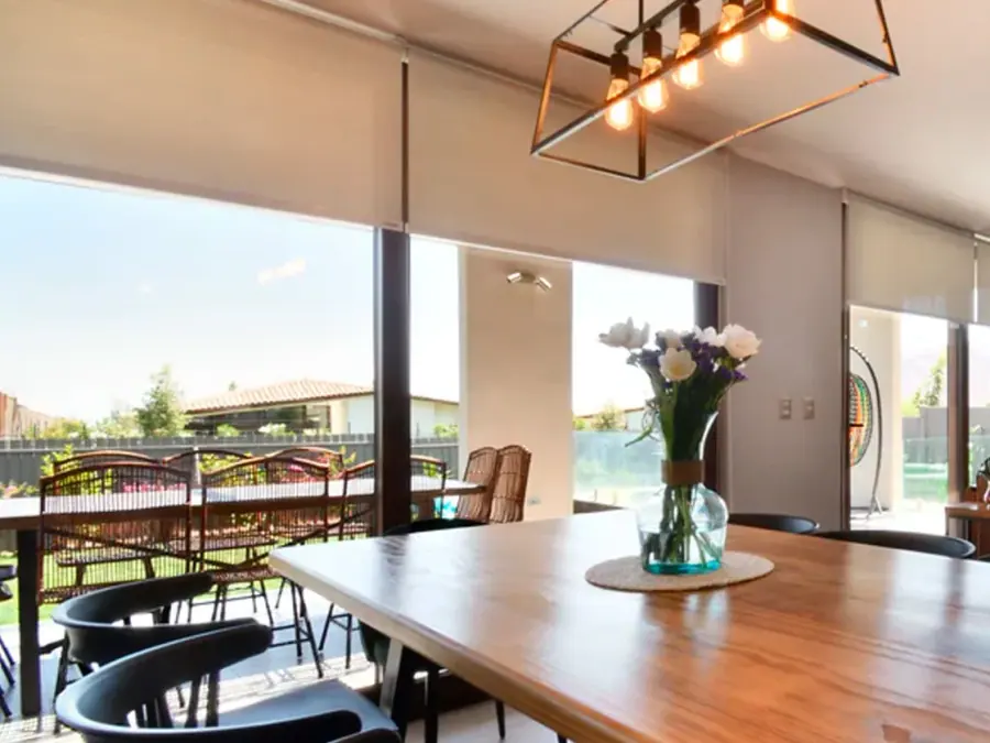 Comedor amplio con cortinas roller screen y vista al exterior