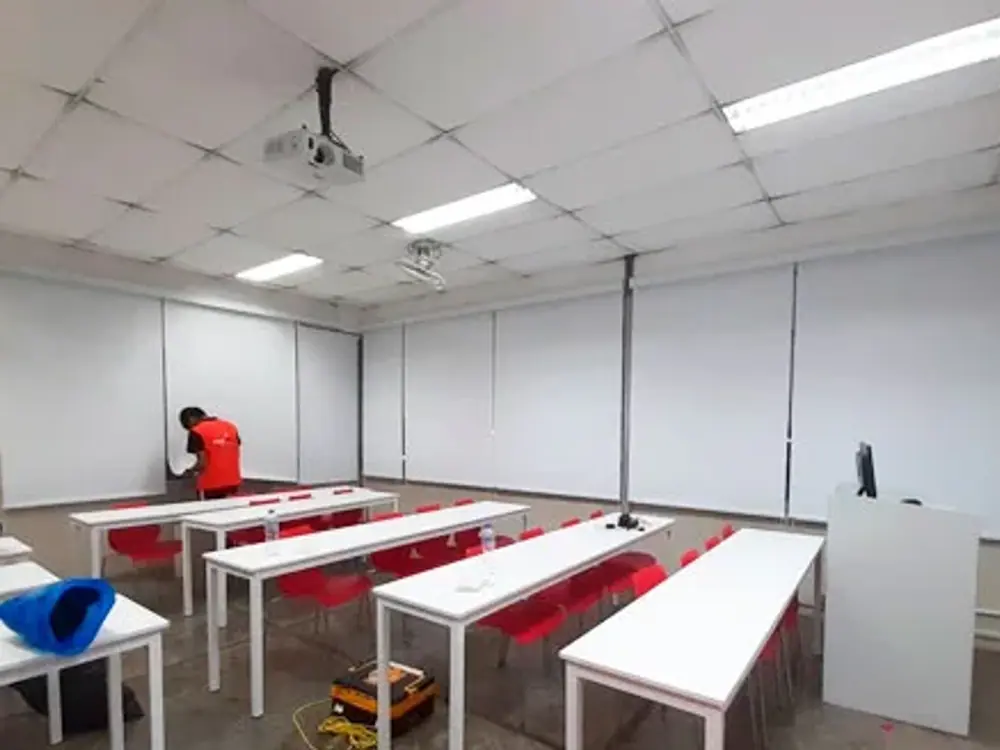 Aula con rollers blackout instalados en toda la pared de ventanas
