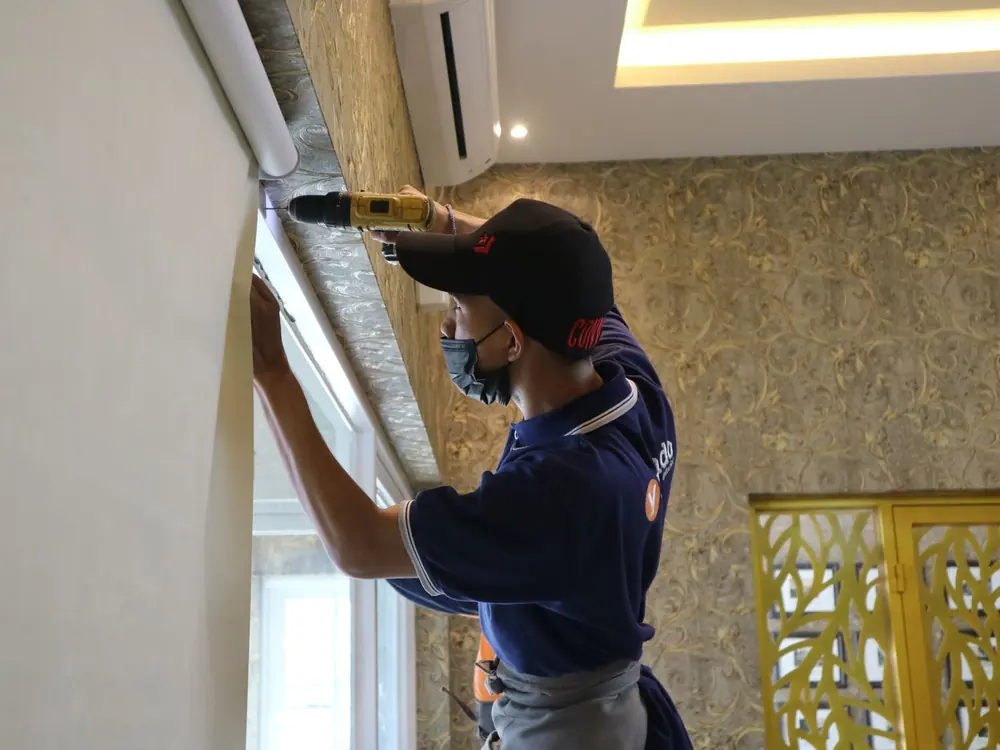 Técnico instalando una cortina roller en una ventana
