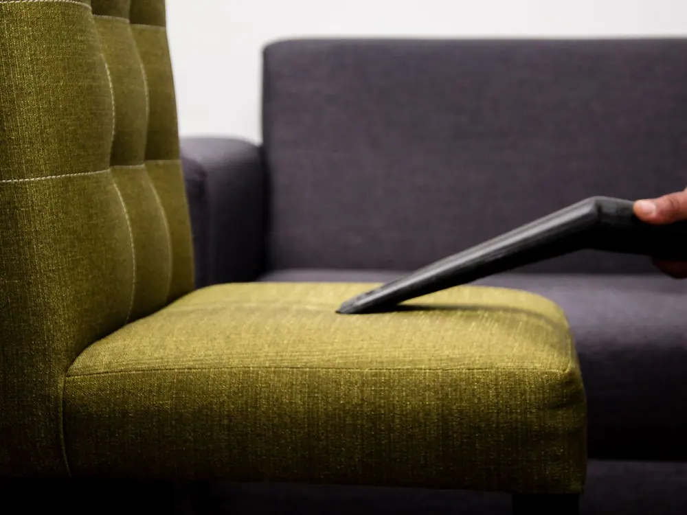 Boquilla de extracción limpiando el asiento de un sillón